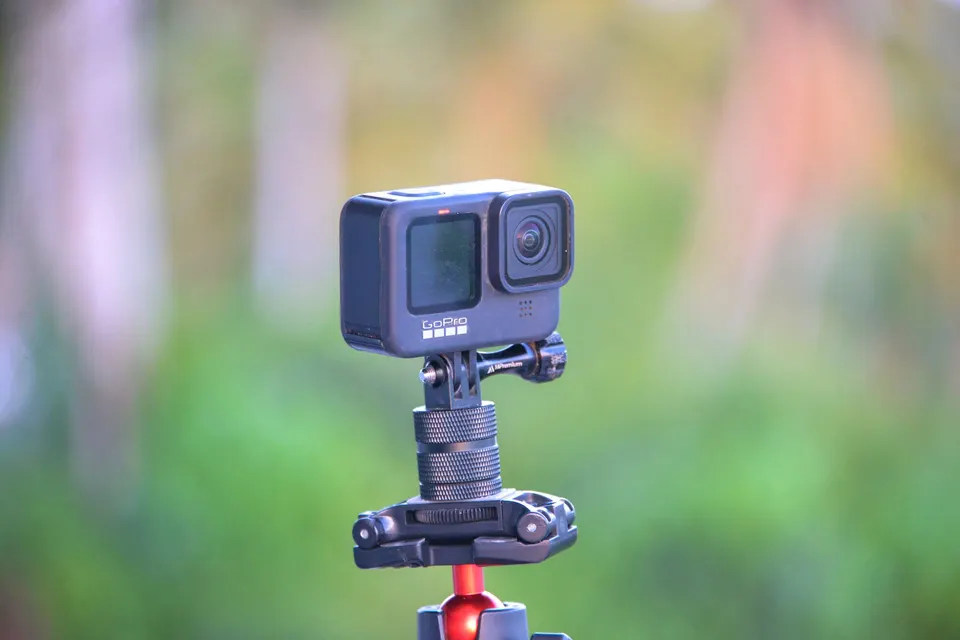 Caméra d’action GoPro montée sur une fixation à rotule, devant un fond de verdure