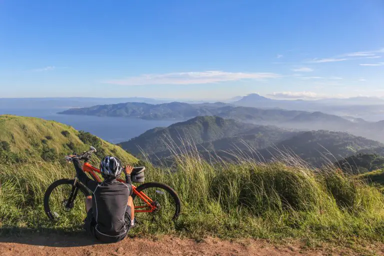 Cycliste avec son casque lavé contemple paysage