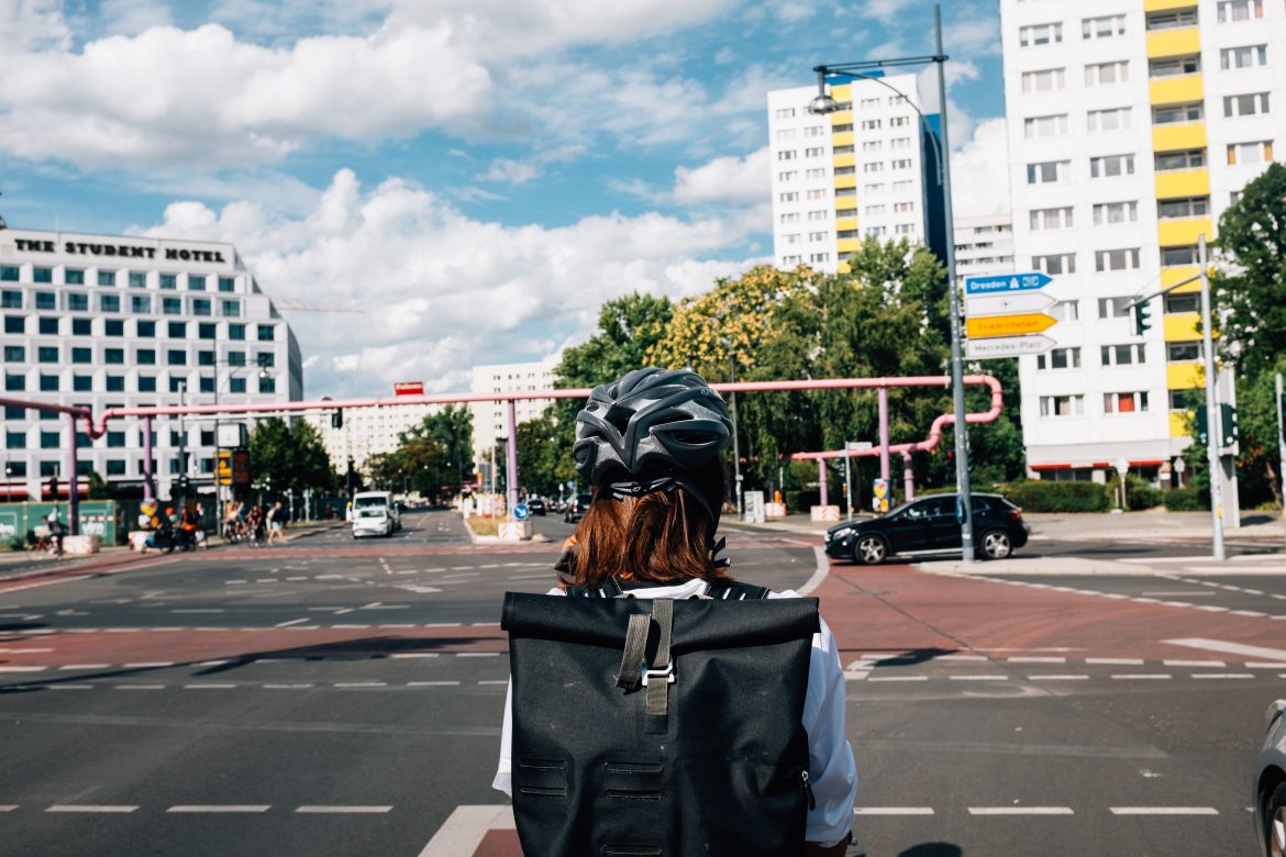 Femme avec son casque vélo attend en sécurité à un croisement sur son vélo
