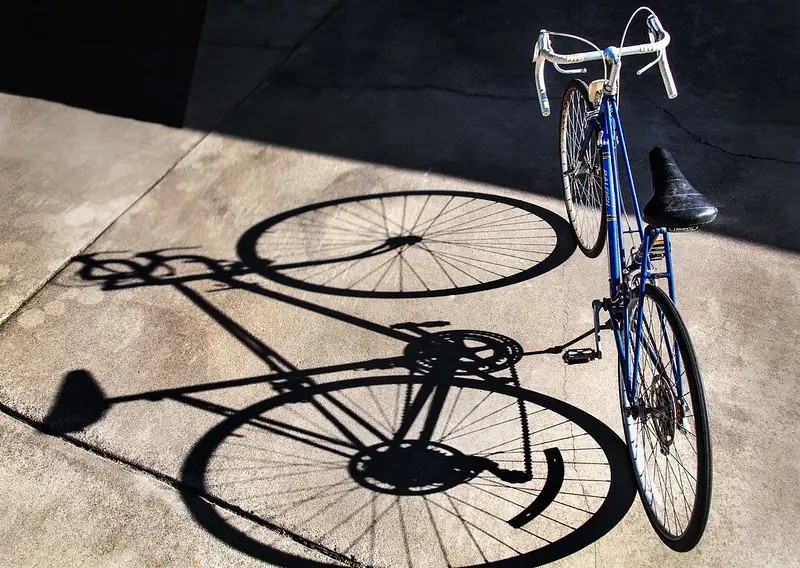 Comment choisir la taille de son vélo ? Vélo avec son ombre projetée en grande taille sur le sol.
