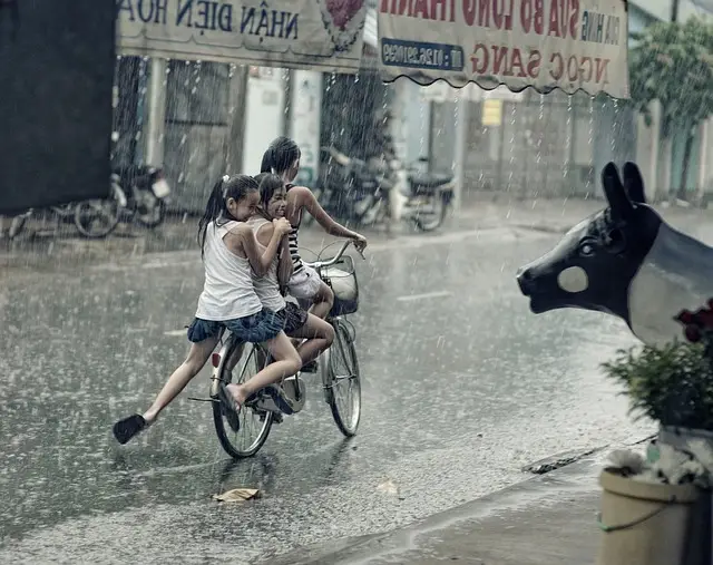 enfants à vélo sous la pluie